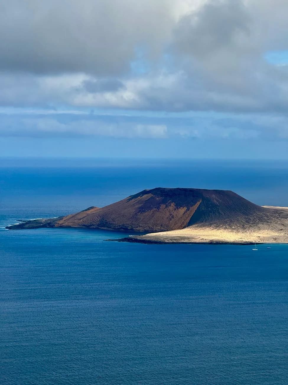 Cône volcanique et plage de sable clair sur la côte nord de La Graciosa