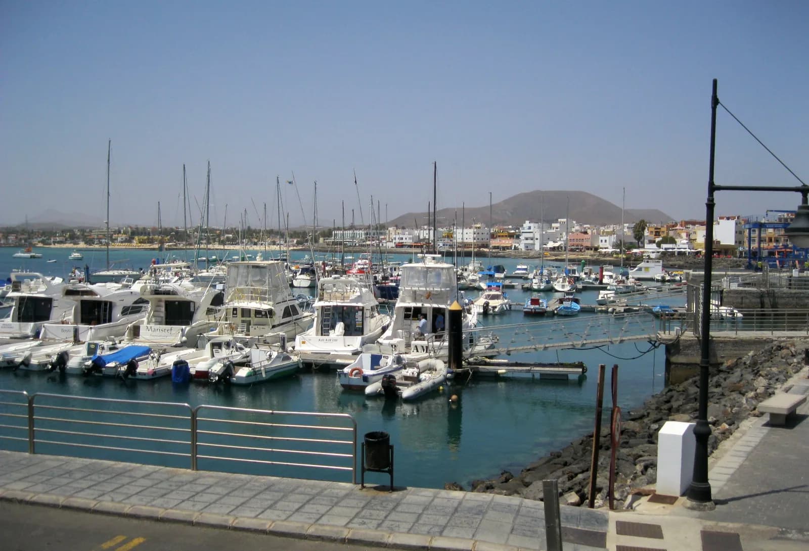 Port de plaisance de Corralejo à Fuerteventura, bateaux amarrés et maisons blanches face à la montagne