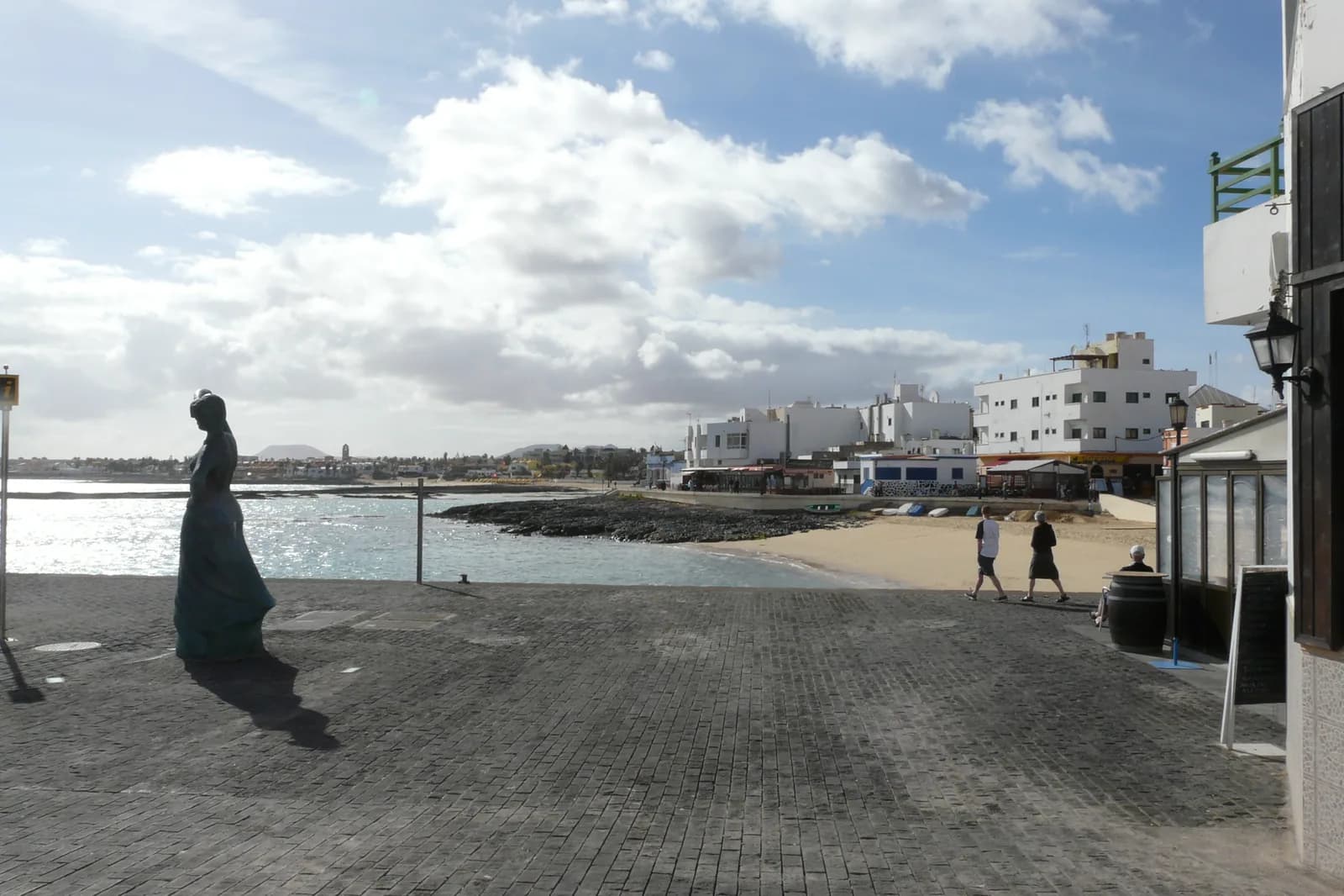 Front de mer du vieux village de Corralejo, statue, petite plage et maisons blanches, Fuerteventura