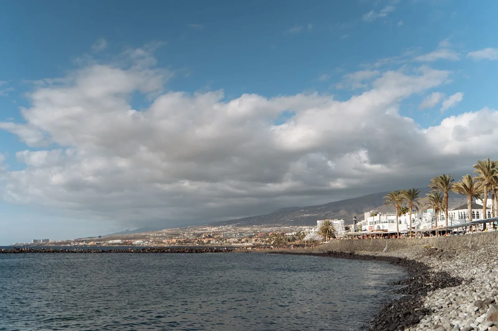 Le littoral du sud de Tenerife vers Costa Adeje, hôtels et palmiers au bord d'une plage de galets