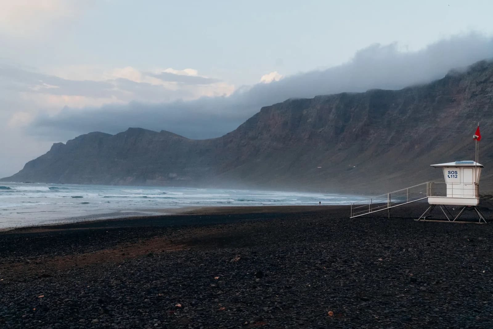 Plage de Famara au nord-ouest de Lanzarote, vagues et Risco de Famara dans la brume