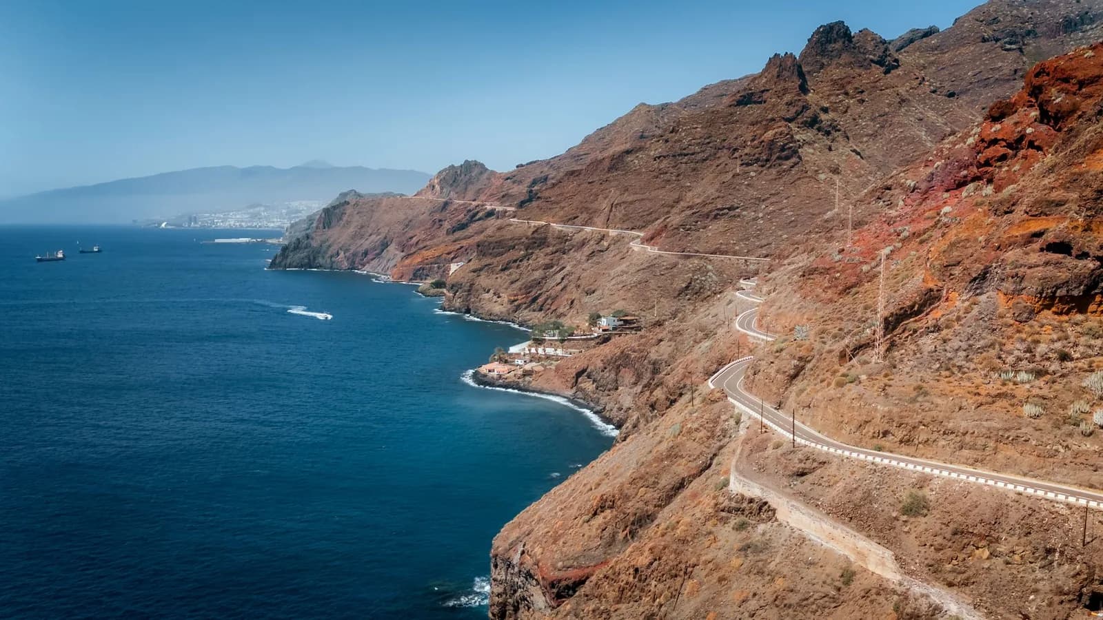 Route côtière taillée dans la falaise au-dessus de San Andrés, avec Santa Cruz de Tenerife et le Teide au fond