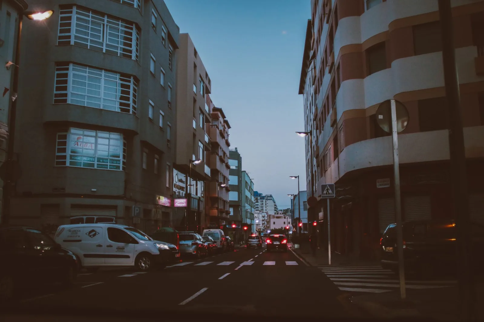 Rue de Santa Cruz de Tenerife en fin de journée, avec des voitures stationnées le long du trottoir