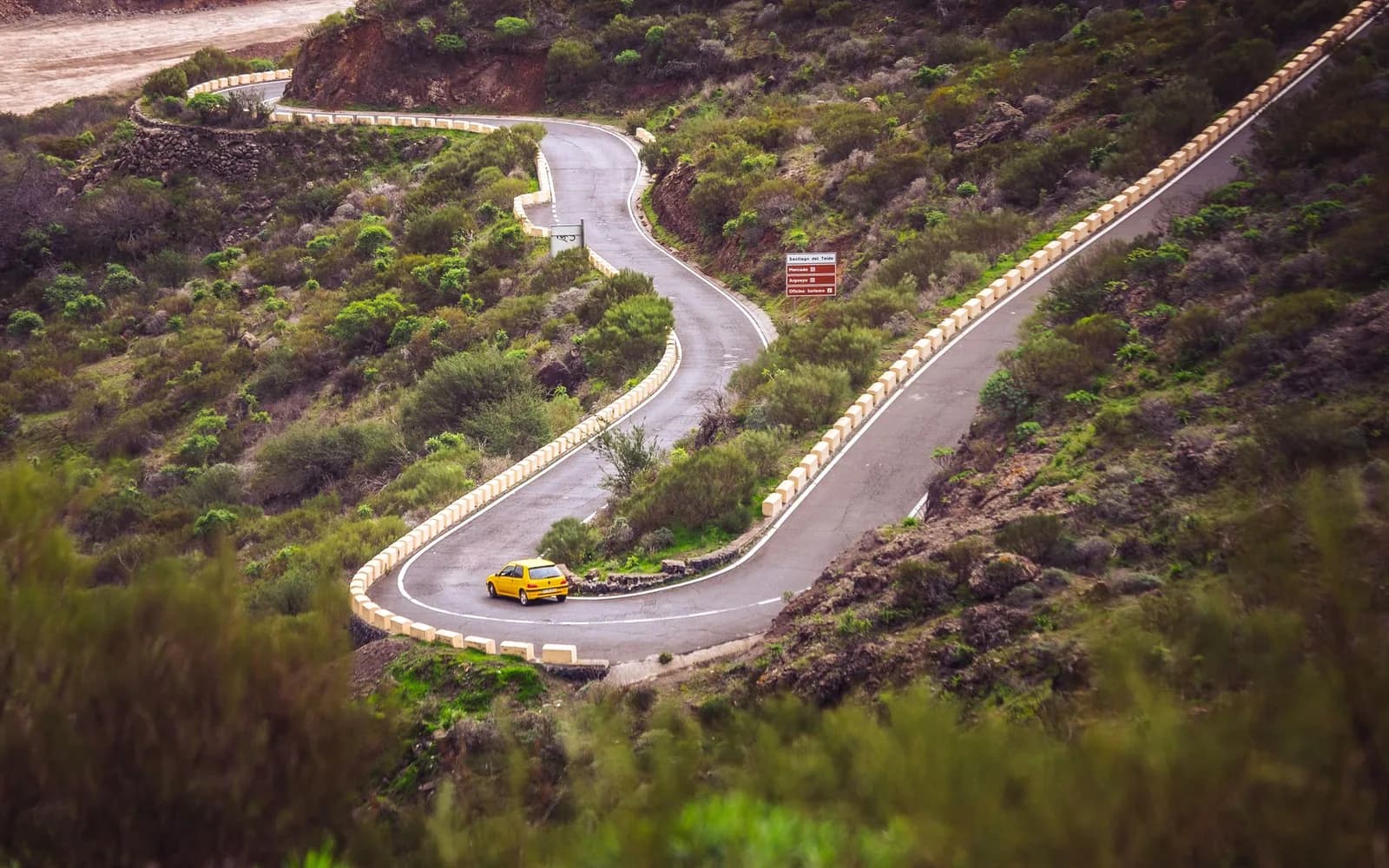 Voiture jaune sur une route de montagne en lacets près de Santiago del Teide, à Tenerife