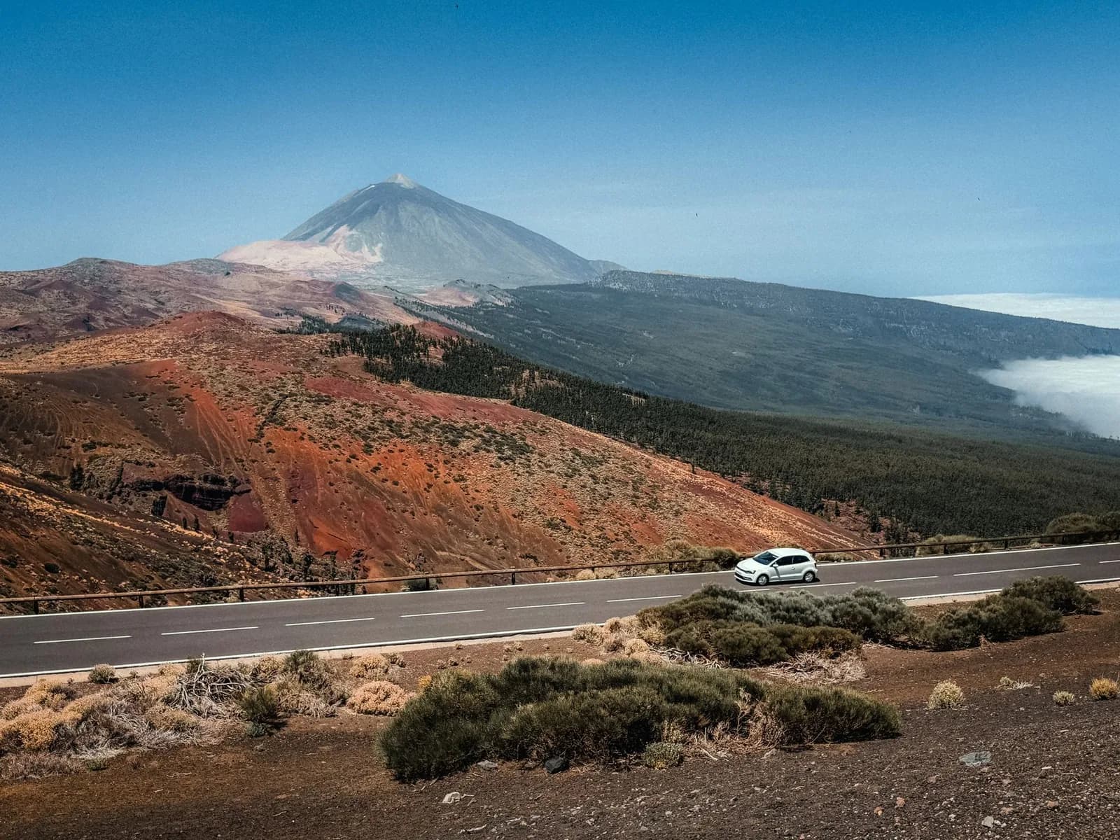 Une voiture sur la route TF-21 dans le parc national du Teide, au-dessus de la mer de nuages, avec le volcan en arrière-plan