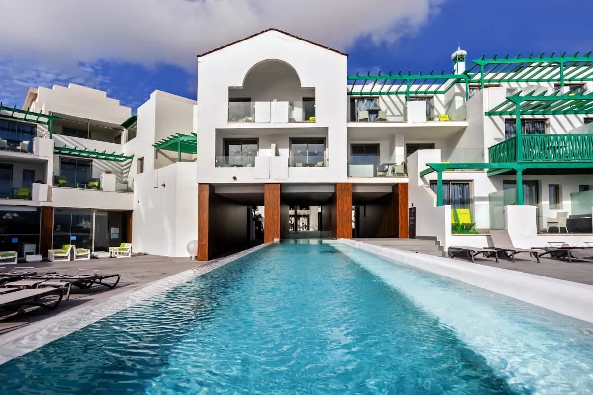 Façade blanche aux boiseries vertes et piscine du Barceló Teguise Beach à Costa Teguise