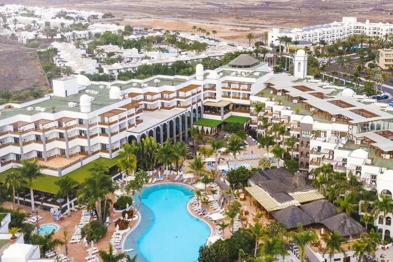Vue aérienne du Princesa Yaiza Suite Hotel Resort à Playa Blanca, sa piscine et les montagnes