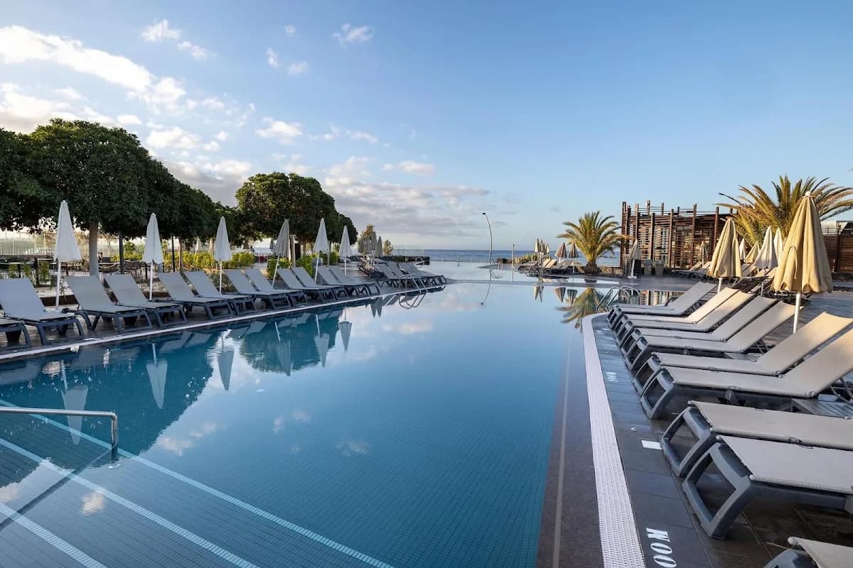 La piscine à débordement du Barceló Tenerife, bordée de transats, à Golf del Sur