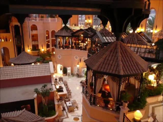 Les pavillons et les toits du Gran Hotel Bahía del Duque éclairés à la tombée de la nuit