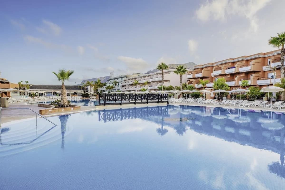 La grande piscine du Landmar Costa Los Gigantes bordée de transats et de palmiers