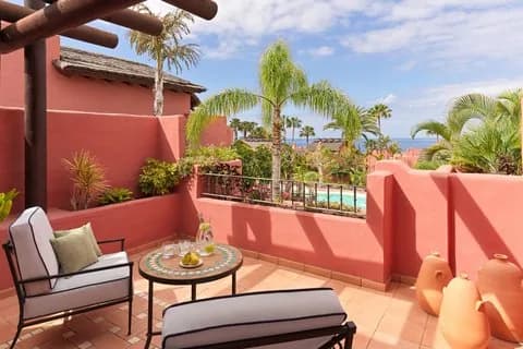 Une terrasse aux murs rouges du Ritz-Carlton Abama avec vue sur l'océan, à Guía de Isora